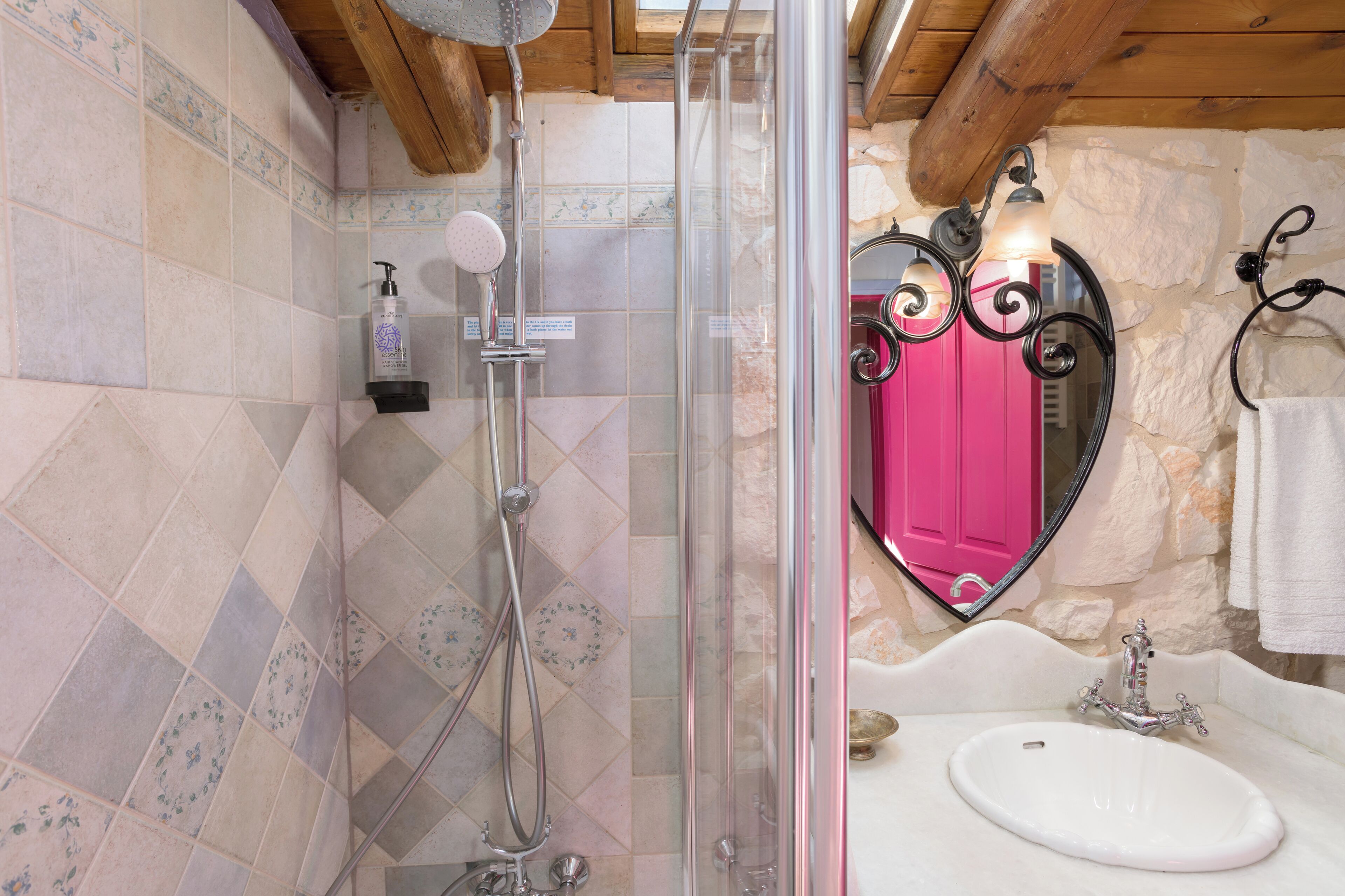 Un baño con ducha, lavabo y espejo.