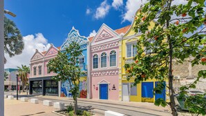 A row of colorful buildings with distinct architectural styles and a clear sky. - Dutch Caribbean Residence B (Oranjestad)