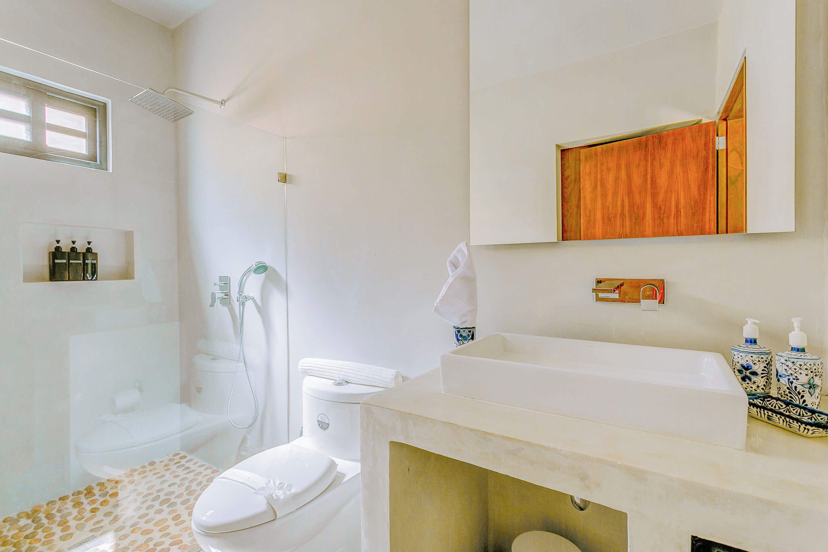 A bathroom with a shower, toilet, and sink.