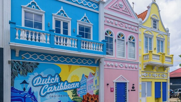 A colorful building with a mural advertising Dutch Caribbean residence. - Dutch Caribbean Residence D (Oranjestad)