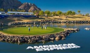 A golf course with a pond, a mountain in the background, and the text 'AMERICAN EXFAMILY' on the water.
