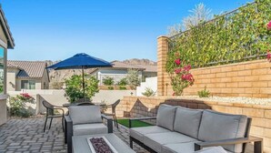 An outdoor patio with a sofa, chairs, and a table. - Desert Hideaway: 2BR/2BA, BBQ, FirePit, PGA West! (La Quinta)