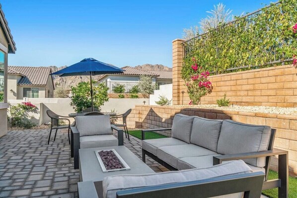 An outdoor patio with a sofa, chairs, and a table.