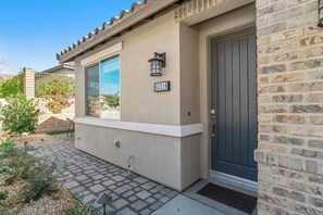 A residential building with a number '80318' on the wall, a window, and a door.