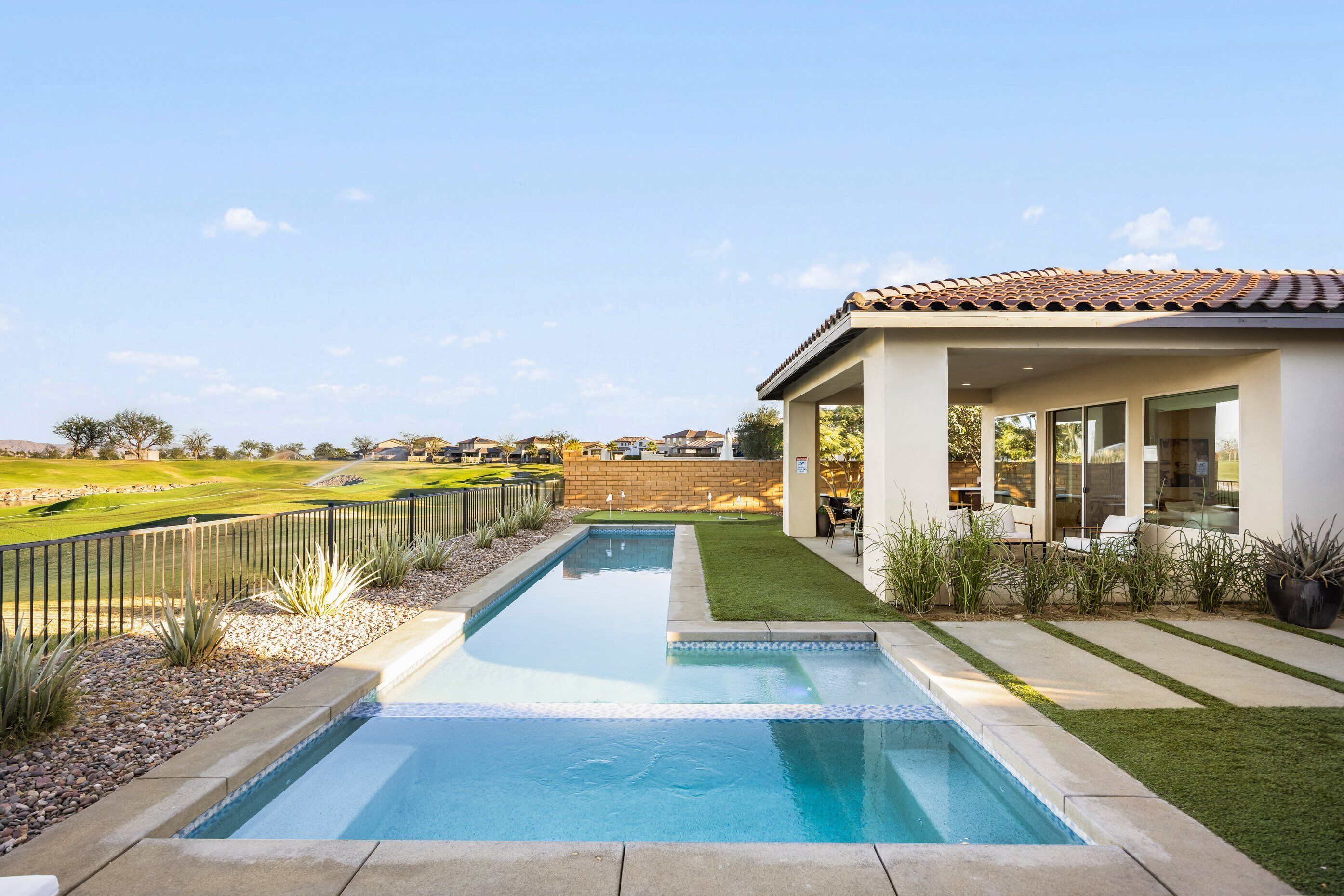 Pool, patio, golf course, and mountains complete the view.