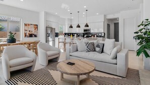 Una sala de estar moderna con sofá, sillones y una mesa de centro.