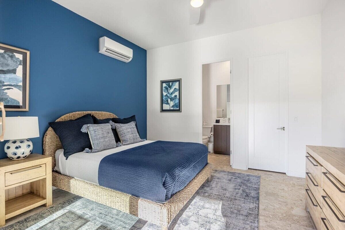 A bedroom with a bed, bedside table, and a dresser.