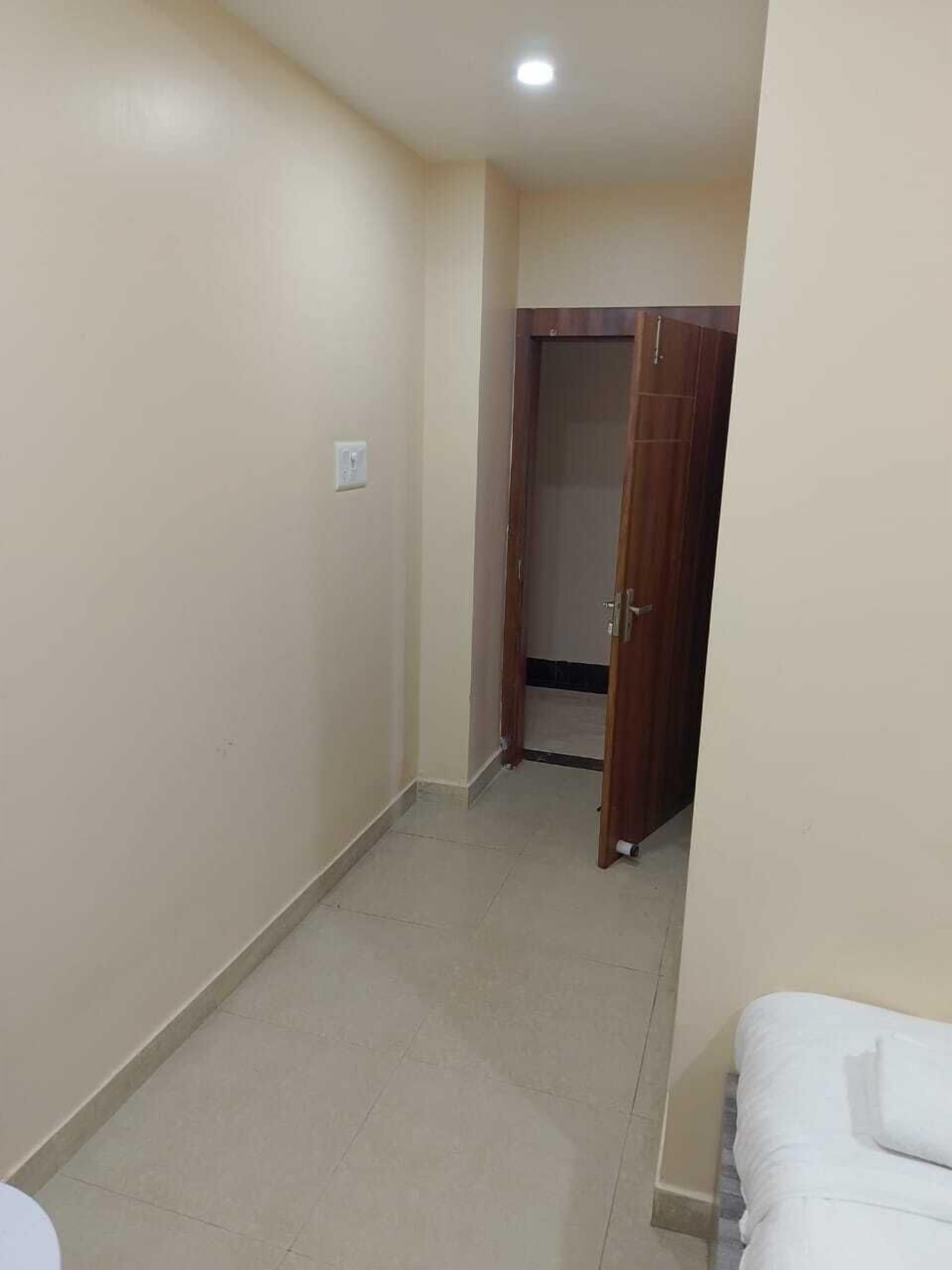 Un pasillo estrecho con una puerta de madera cerrada al final.