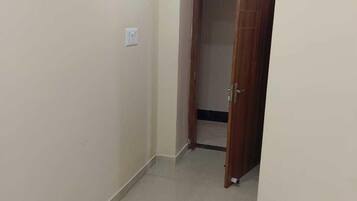 Un pasillo estrecho con una puerta de madera cerrada al final.