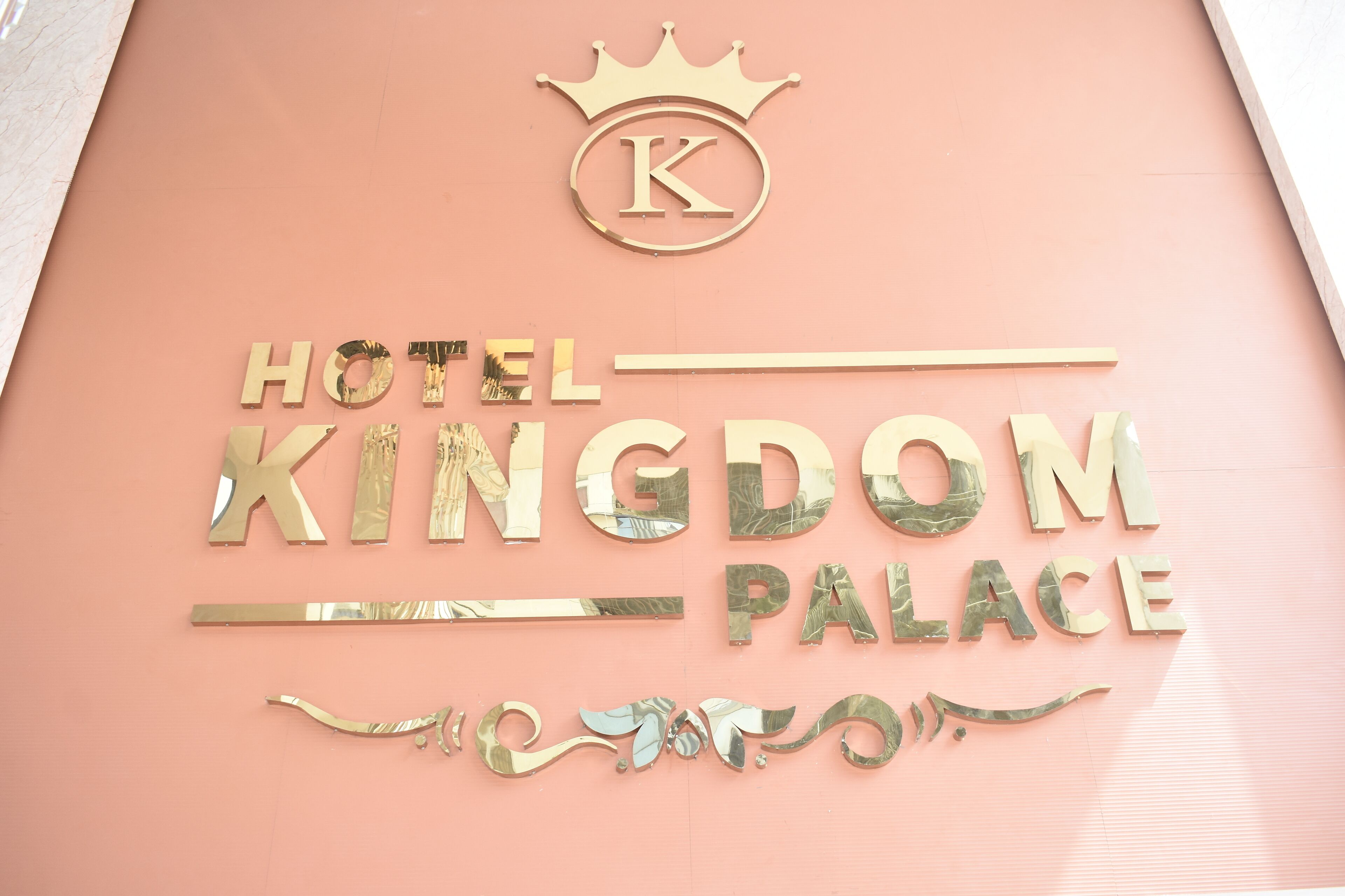 Een bord voor Hotel Kingdom Palace, met een kroon symbool en de letter 'K' boven de naam.