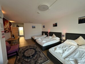 Ein Hotelzimmer mit zwei Betten, einem Schreibtisch, einem Sessel und einem großen Teppich.
