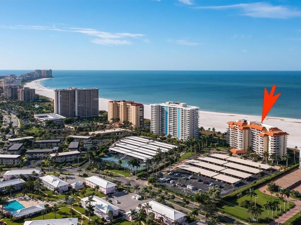 A coastal resort area with high-rise hotels, a beach, and a parking lot.