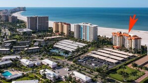 A coastal resort area with high-rise hotels, a beach, and a parking lot. - Beachfront 1BR condo on Marco Island with pool, WiFi, and kitchen (Marco Island)