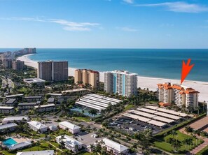 A coastal resort area with high-rise hotels, a beach, and a parking lot.