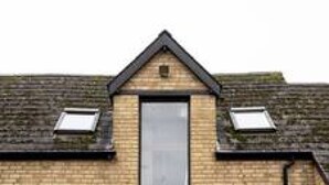 A two-story brick house with a central door, two windows on the upper floor, and a small garden area with a gravel path. - Charming Oxford Cottage (Oxfordshire)