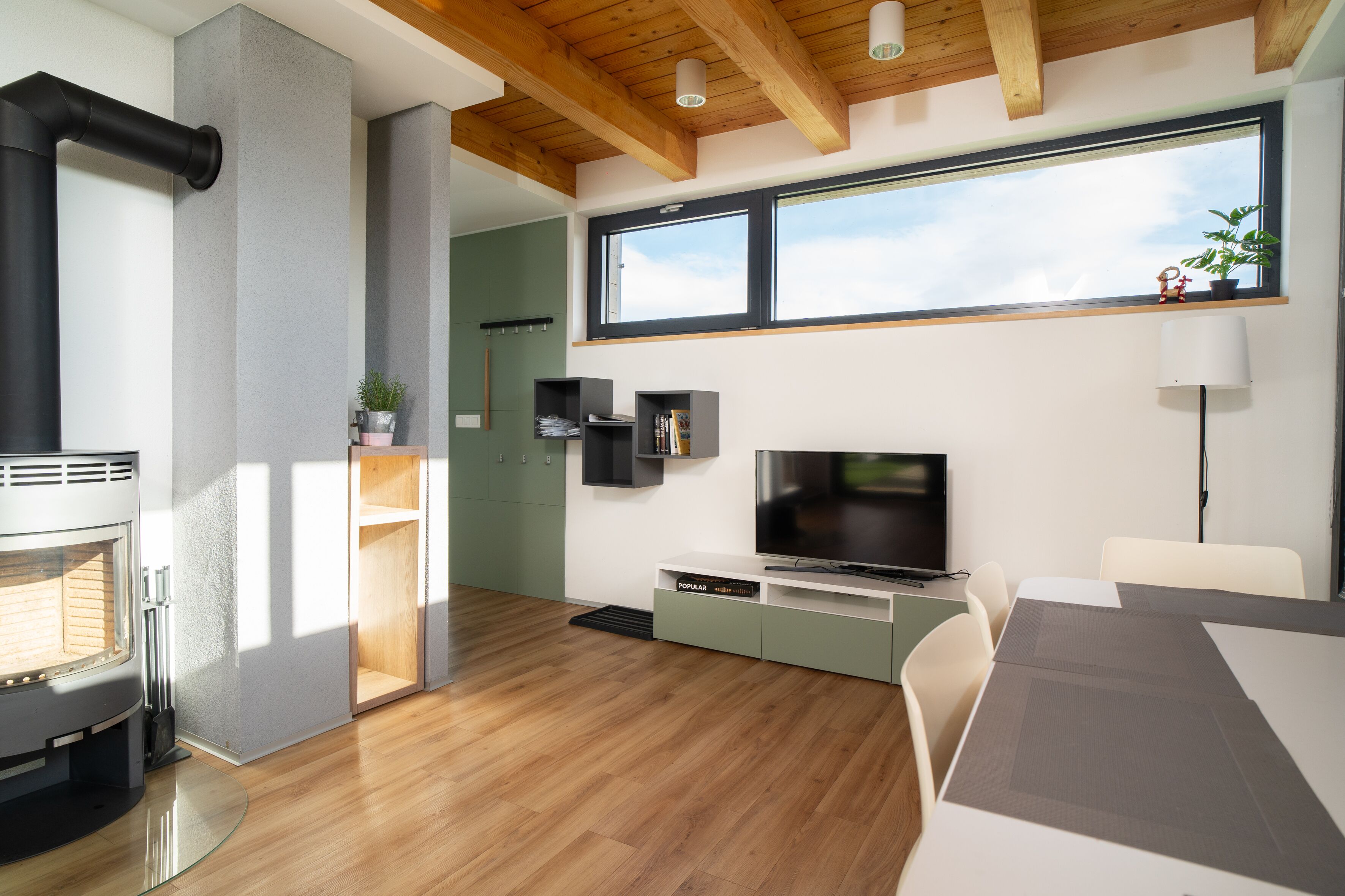 Una sala de estar moderna con chimenea, televisor y comedor.