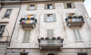 A building with ornate architectural details, multiple balconies with railings, and a central entrance.