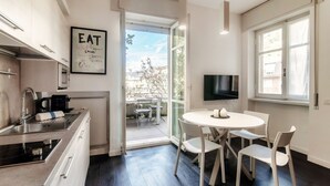 Uma cozinha moderna com área de refeições, televisão e vista para o exterior.