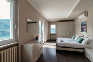 Une chambre à coucher avec un lit, une commode et une fenêtre donnant sur l’extérieur.