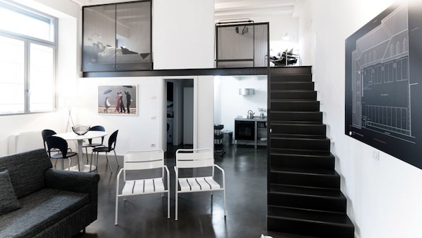 Eine moderne Loft-Wohnung mit Treppe, Essbereich und Wohnzimmer.