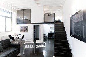 A modern loft-style apartment with a staircase, a dining area, and a living room. - Porta Torre Loft - My Home in Como (Como)