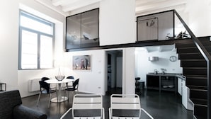 Eine moderne Wohnung mit Essbereich, Küche und einer Treppe.