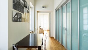 A modern kitchen with a dining area, a view of the city, and a glass door leading to a balcony. - Via Rusconi 10 - My Home In Como (Como)