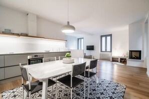 Una cocina moderna con comedor, chimenea y televisor.
