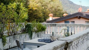 A terrace with a table, chairs, a bottle of champagne, and a decorative plant.