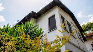 Un edificio moderno con tetto spiovente, ampie finestre e facciata bianca.