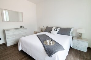 A neatly arranged bedroom with a bed, bedside tables, a dresser, and a mirror. - Casa Fiona - My Home In Como (Nesso)