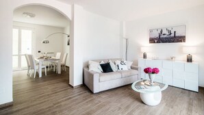 Un salon moderne avec un canapé, une table basse et un tableau accroché au mur.
