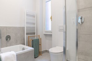 A modern bathroom with a bathtub, a toilet, and a shower area. - Como Lake Vista - My Home in Como (Blevio)