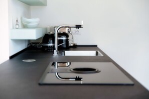 A modern kitchen with a built-in coffee maker, a sink, and a countertop.