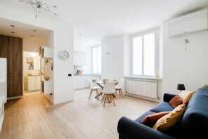 A modern apartment with a dining area, kitchen, and living room.