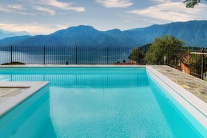 Une piscine avec vue sur les montagnes et un lac.