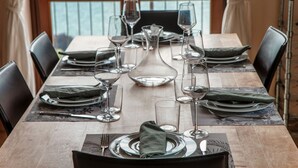A dining table set for a meal with chairs, plates, glasses, and cutlery.
