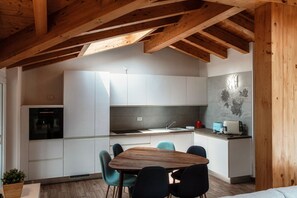 Una cocina moderna con armarios blancos, una mesa de comedor de madera y sillas azules.