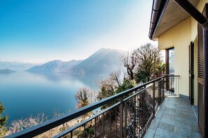 Un balcón con vistas a un lago y montañas.