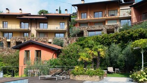 A multi-story residential building with balconies, a swimming pool, and a landscaped garden. - Bella Lì - MyHomeInComo (Menaggio)