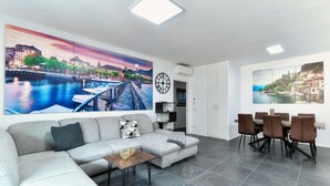 Ein modernes Wohnzimmer mit einer Couch, einem Couchtisch und einem Essbereich mit Stühlen.