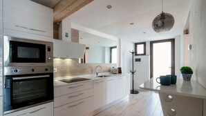 A modern kitchen with built-in appliances, a central island, and a pendant light. - Acqua - My Home in Como (Moltrasio)