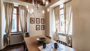 A dining area with a wooden table, a bowl, and four mugs.