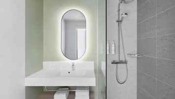 Un baño moderno con lavabo blanco, un espejo grande y una ducha.