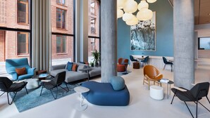 A modern lounge area with seating arrangements, large windows, and decorative lighting. - Fairfield By Marriott Copenhagen Nordhavn (Copenhagen)