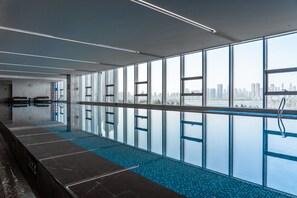 An indoor swimming pool with a city view, large windows, and a modern design. - Wuhan Marriott Hotel Wuchang (Wuhan)
