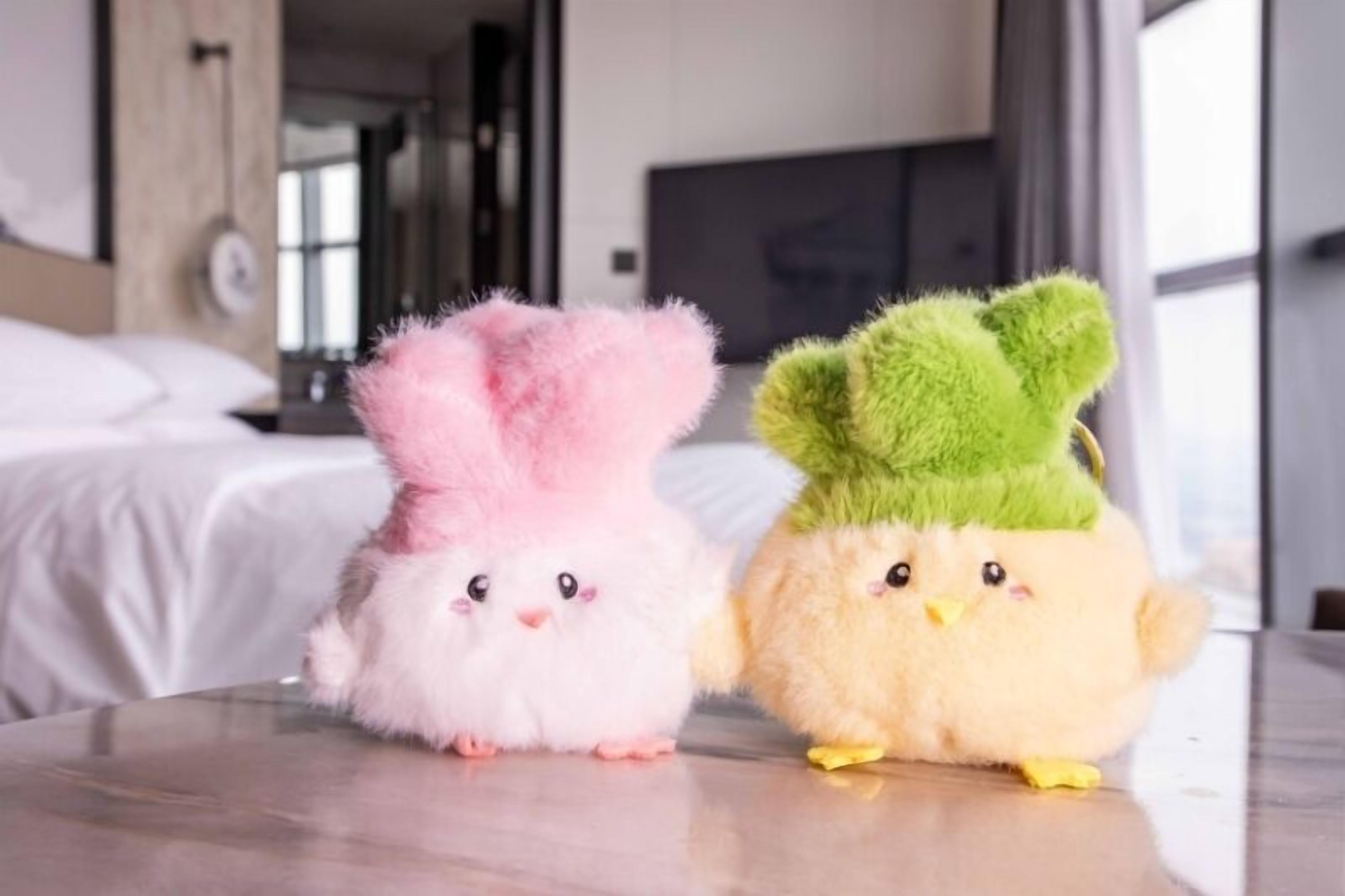Dos peluches sobre una mesa en una habitación de hotel.
