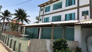 A multi-story building with large windows and a flat roof. - Village no Condominio Arauá, Fechado com Trilha Para Caminhada, Academia (Condomínio Arauá Vera Cruz)