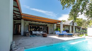 A poolside area with lounge chairs, a dining table, and a covered seating area with a view of the pool. - Franschhoek Homestead Cottage (Franschhoek)