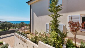 A building with a balcony overlooking a garden and a view of the sea. - MEACres Sun - secluded pool villa (Miholašćica)